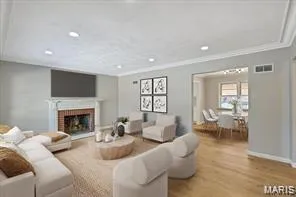 Living area with wood finished floors, a fireplace, recessed lighting, and crown molding