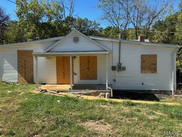 View of front of property with a front lawn, crawl space, and a patio