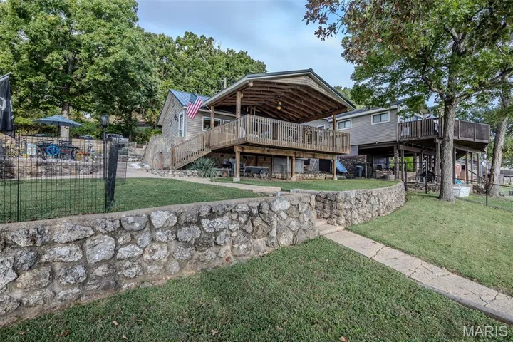 Rear view of property with stairs, a deck, and a metal roof