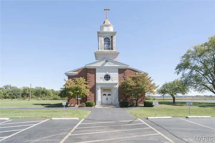 View of building exterior with plenty of parking