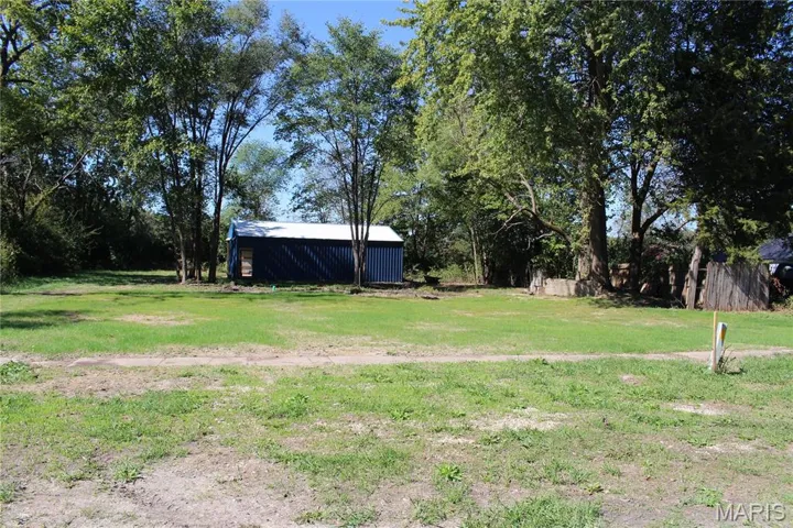 View from street of lot and outbuilding