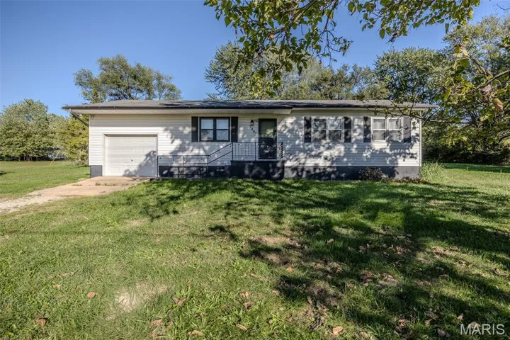 Ranch-style home featuring a front lawn, driveway, and an attached garage