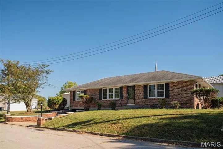 Single story home featuring brick siding and a front lawn