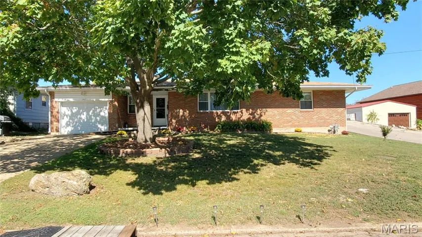 Single story home with concrete driveway, a front yard, brick siding, and an attached garage