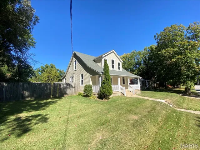 View of front facade featuring covered porch and roof with shingles