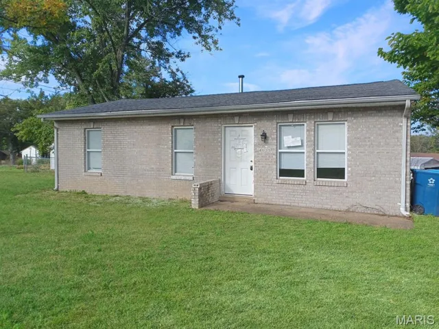 View of front facade with a front lawn, brick siding, and roof with shingles