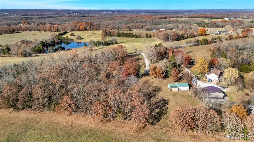 View of property location featuring a nearby body of water and a heavily wooded area