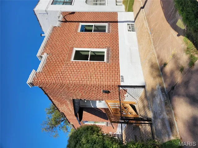 View of home's exterior featuring a gate and brick siding