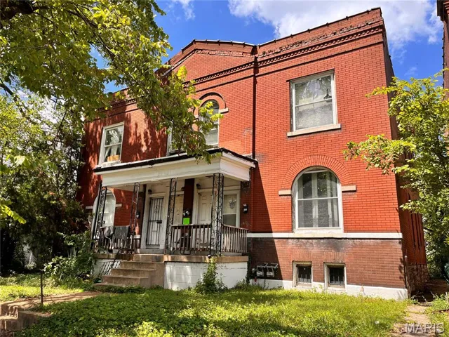 View of front of property with brick siding and a porch