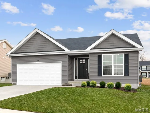 Ranch-style home with a front yard, driveway, and a garage
