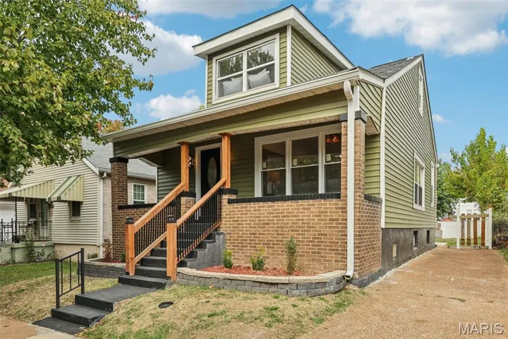View of front of home with a porch and brick siding