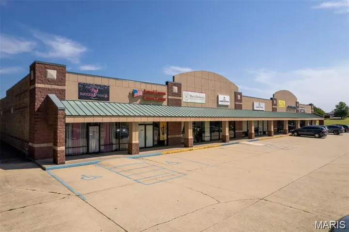View of commercial property featuring uncovered parking