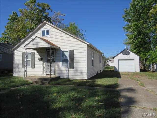 View of front of home with a front lawn and a detached garage