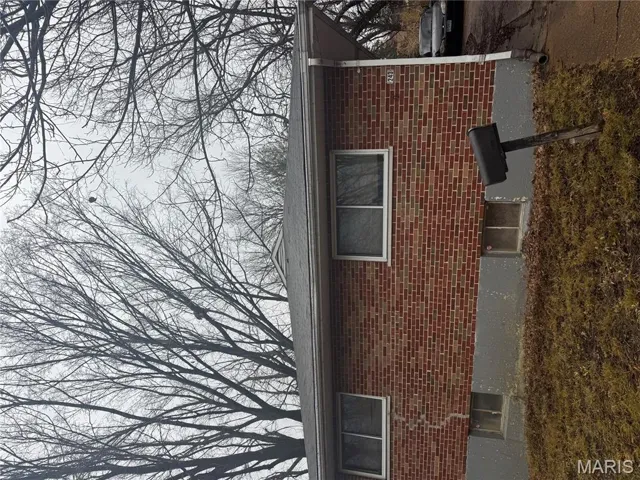 View of property exterior with brick siding
