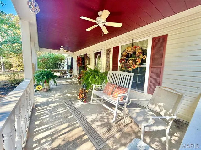 Covered porch featuring ceiling fan