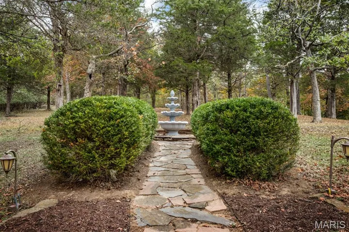 Beautiful stone walkway from fountain leading up to home