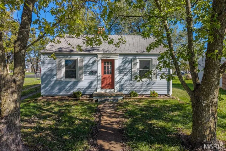 View of front of home featuring a front yard and a shingled roof