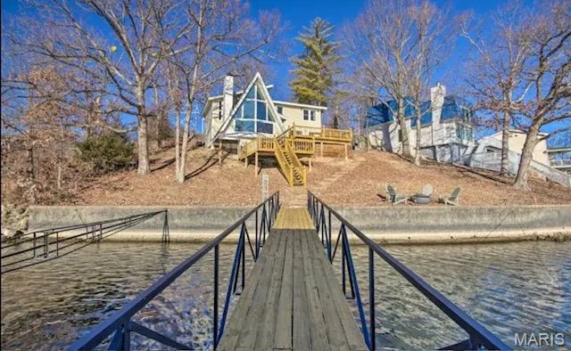 Dock area with stairway and a deck with water view