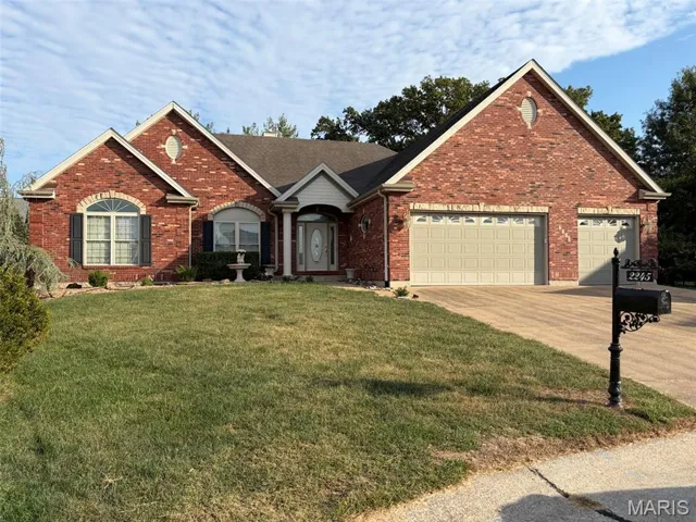 Single story home with brick siding, concrete driveway, a front yard, and a garage
