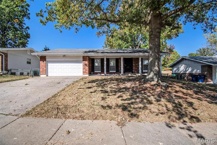 Ranch-style house featuring brick siding, covered porch, driveway, and a garage