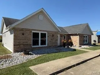 Ranch-style house with a front yard and brick siding
