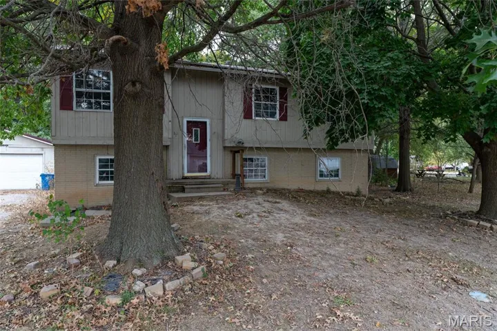 Raised ranch featuring brick siding and a garage