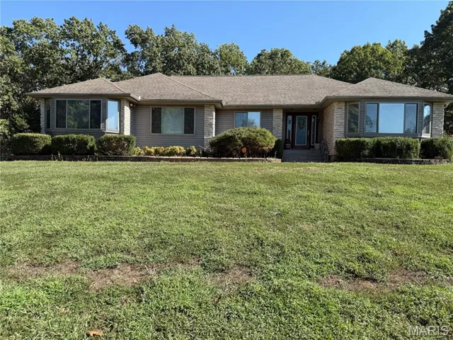 Ranch-style house with a front lawn and roof with shingles