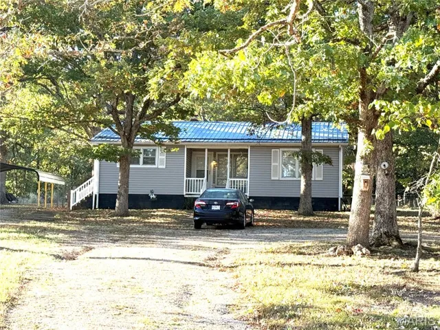View of front of home featuring a metal roof and driveway