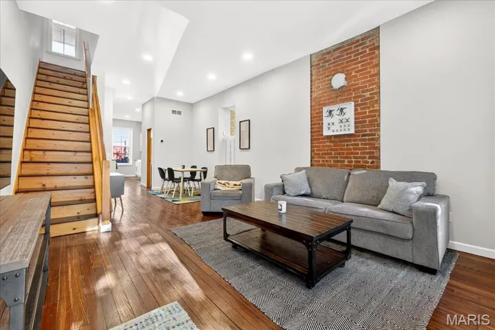 Living room featuring soaring ceilings and exposed brick walls
