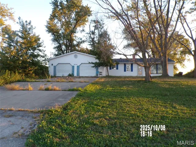 Ranch-style home featuring a front lawn and a garage