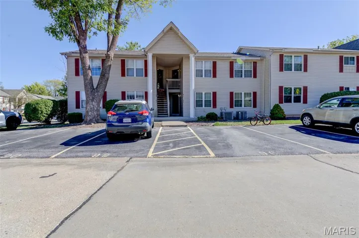 View of building exterior featuring uncovered parking