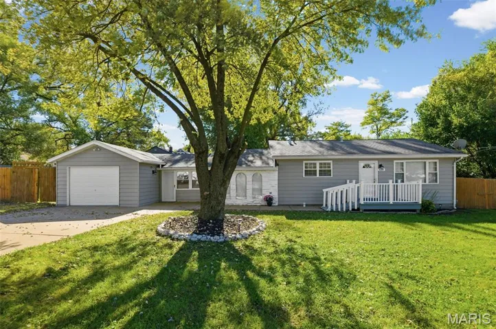 Ranch-style house featuring concrete driveway and a deck