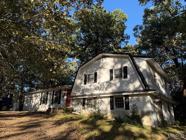 View of front of house featuring a gambrel roof, a metal roof, and a standing seam roof