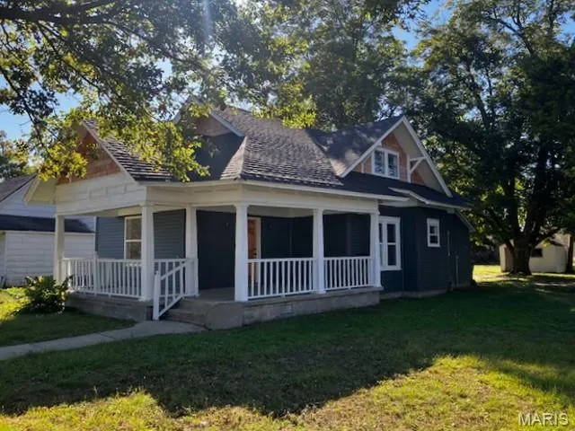 Bungalow-style home featuring a porch and a front yard
