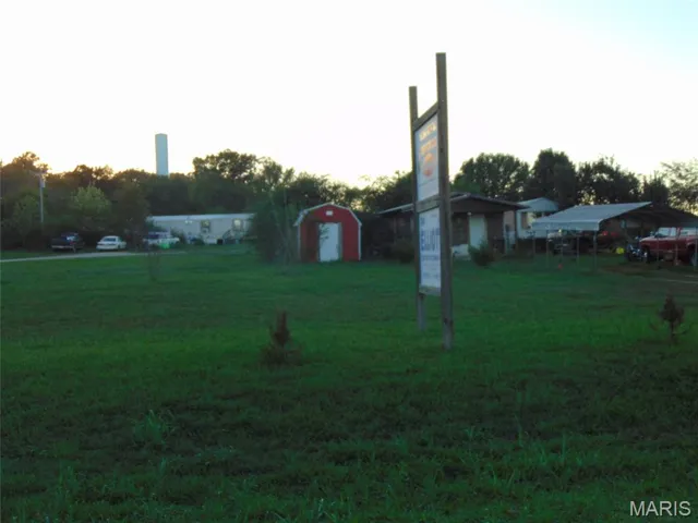 View of grassy yard with a storage shed and a carport