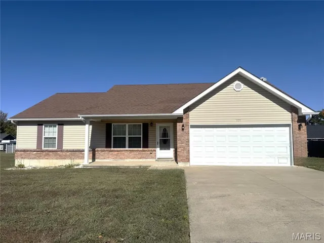 Single story home featuring a porch, concrete driveway, brick siding, a front yard, and an attached garage