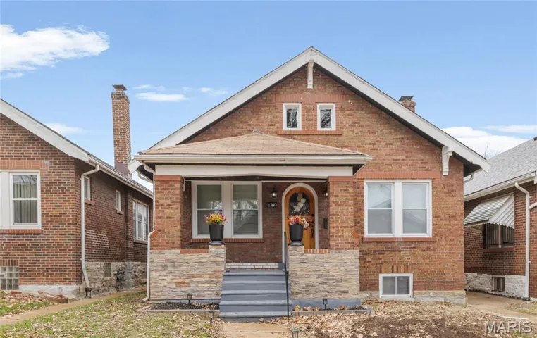 Bungalow-style home with brick siding and a porch