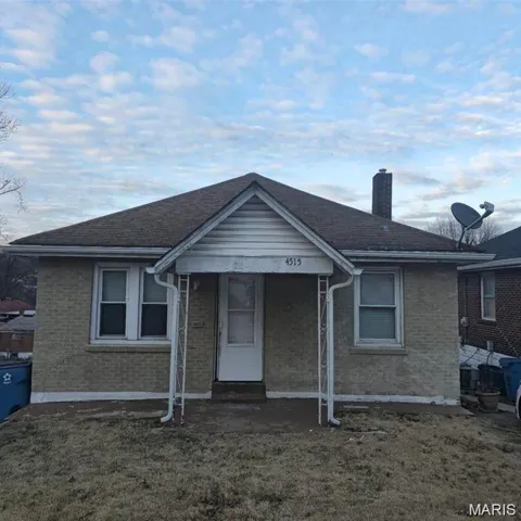 Bungalow-style home featuring a chimney, brick siding, and covered porch