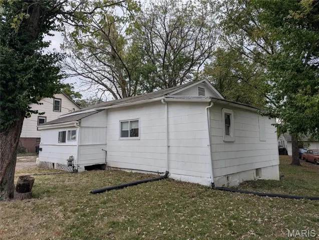 View of side of property featuring a lawn