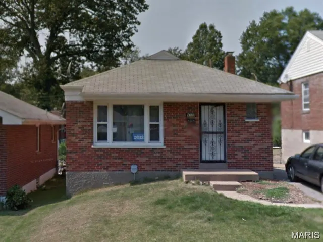 Bungalow-style house with a front yard, a chimney, and brick siding