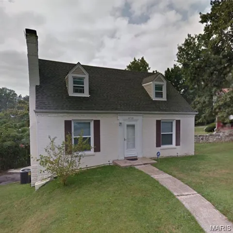 Cape cod home with a front yard, a chimney, and roof with shingles