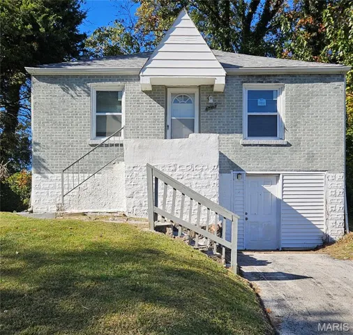 View of front facade featuring stairs, a front yard, and brick siding
