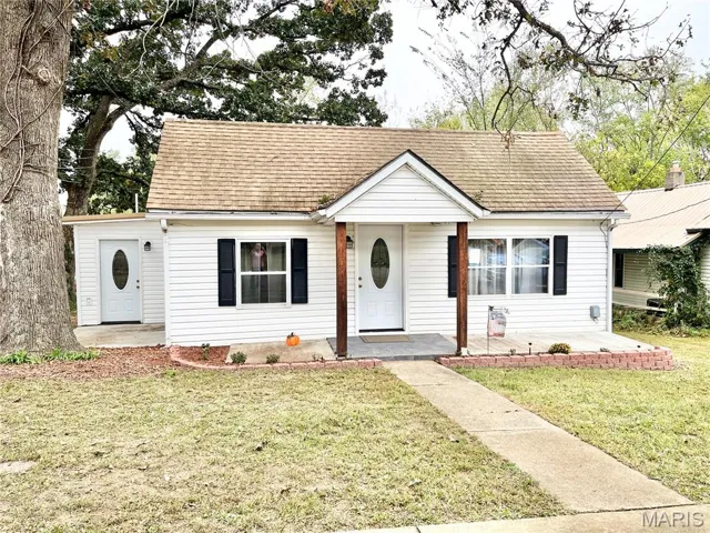 Bungalow-style house featuring a front lawn and a shingled roof