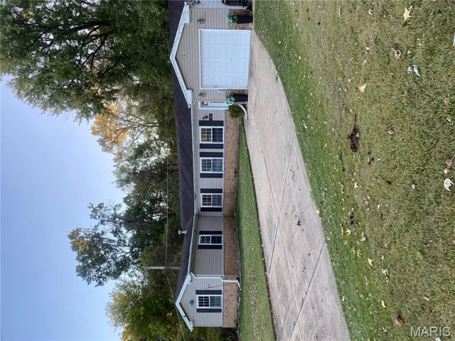 Single story home featuring brick siding, concrete driveway, a front lawn, and a garage