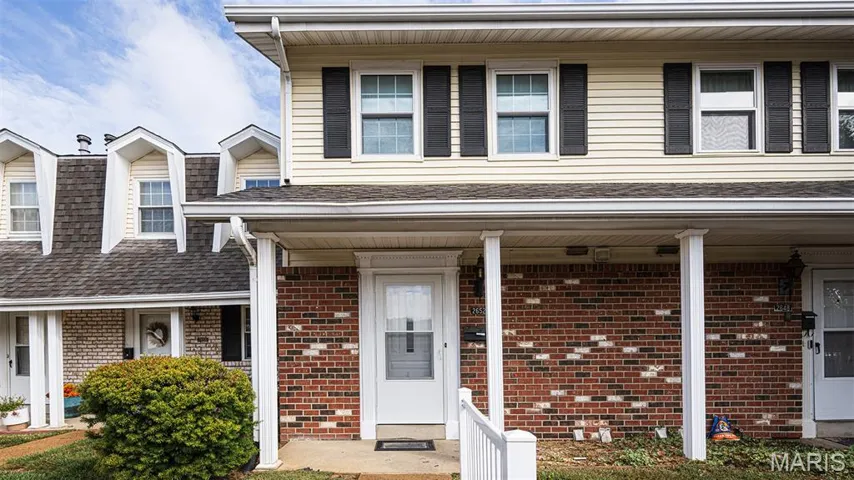 View of front of property with covered porch and brick siding