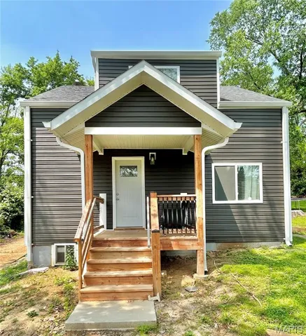 View of front of house with covered porch and a shingled roof