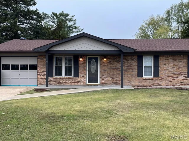 Single story home with a front lawn, roof with shingles, an attached garage, and brick siding
