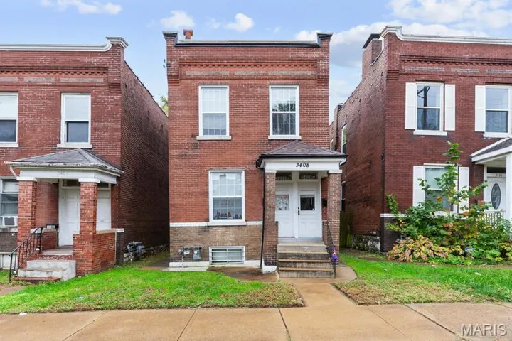 View of front of home featuring brick siding and a front lawn