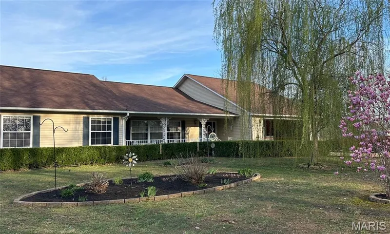 View of front of home featuring a front lawn and roof with shingles