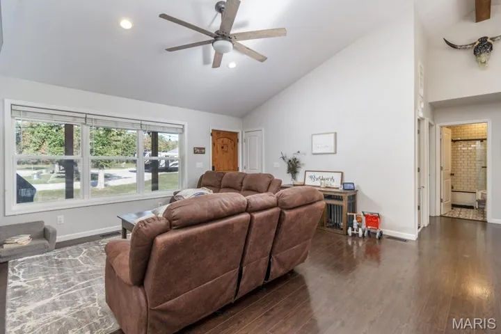 Living area with high vaulted ceiling, dark wood-type flooring, a ceiling fan, and recessed lighting